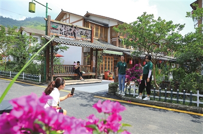 竹山镇猎神村,游客在猎神三巷拍照游玩。资料图